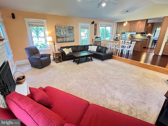 6206 Pinehurst Rd, Baltimore, MD 21212 - carpeted living area with lofted ceiling, a ceiling fan, a fireplace with flush hearth, wood finished floors, and baseboards