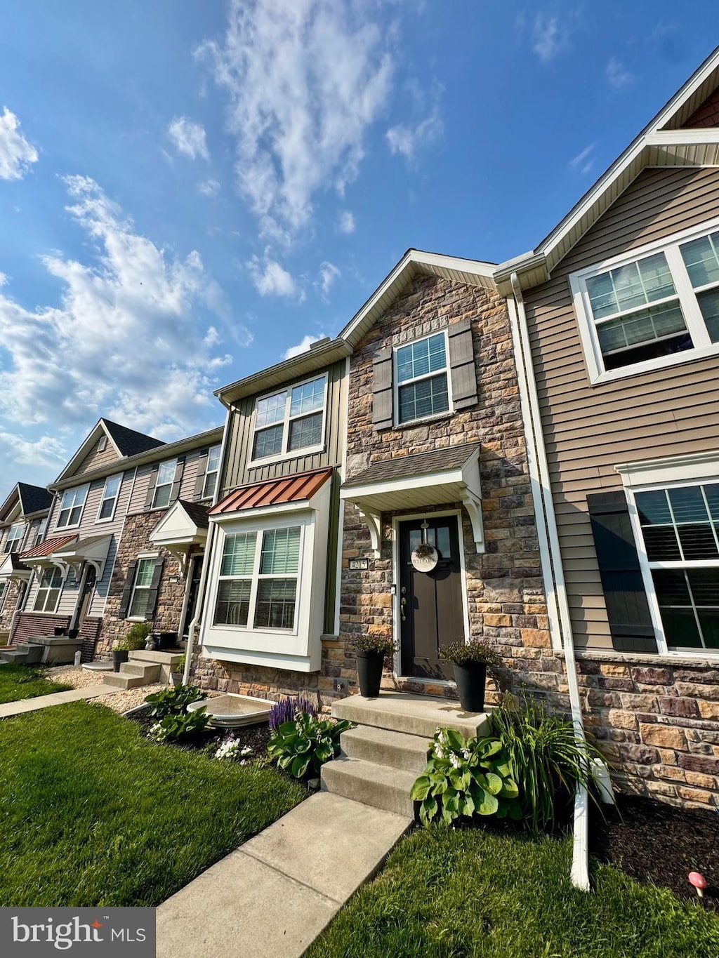 4215 Wild Orchid Ln, Enola, PA 17025 - townhome / multi-family property featuring stone siding and a front lawn