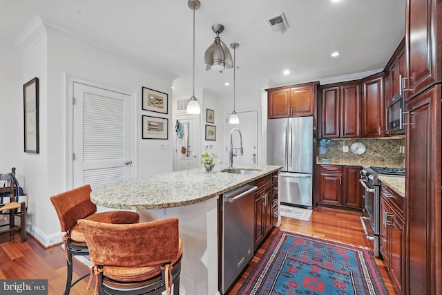 1023 N Royal St Unit 207, Alexandria, VA 22314 - kitchen with appliances with stainless steel finishes, a sink, wood finished floors, an island with sink, and ornamental molding