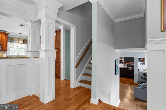 872 Kilby Dr, Yardley, PA 19067 - stairs with wood finished floors, a lit fireplace, ornamental molding, and ornate columns