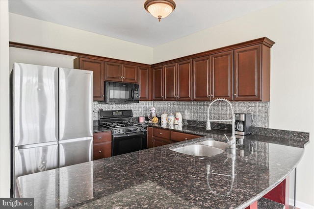 213 Joseph Rd, Oxford, PA 19363 - kitchen with freestanding refrigerator, black microwave, gas range, a sink, and tasteful backsplash