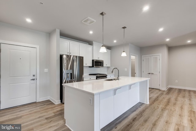 42 Liberty Rd Unit M, Sykesville, MD 21784 - kitchen with appliances with stainless steel finishes, a sink, light wood-style floors, white cabinets, and a center island with sink