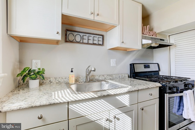 3835 26th Ave, Temple Hills, MD 20748 - kitchen with stainless steel gas range oven, under cabinet range hood, a sink, and white cabinets