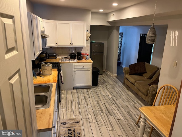 312 W Princess St, York, PA 17401 - kitchen with white cabinets, a sink, backsplash, light wood-style floors, and recessed lighting