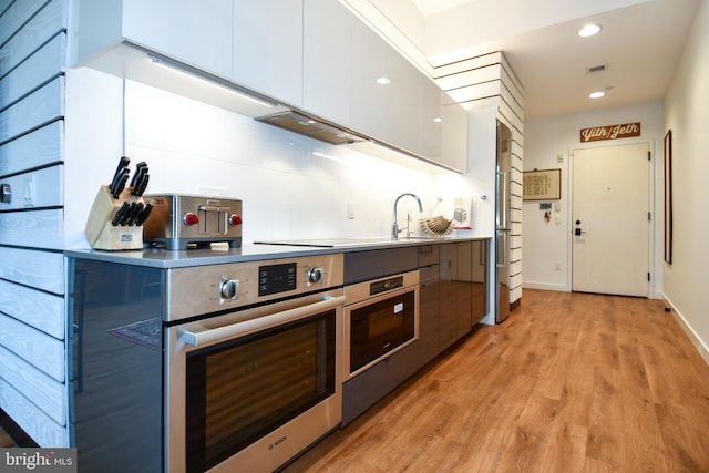 57 N St NW Unit 301, Washington, DC 20001 - kitchen with modern cabinets, stainless steel oven, light wood-style flooring, and recessed lighting