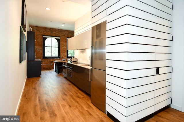57 N St NW Unit 301, Washington, DC 20001 - kitchen featuring modern cabinets, stainless steel refrigerator, brick wall, light wood-type flooring, and wall oven
