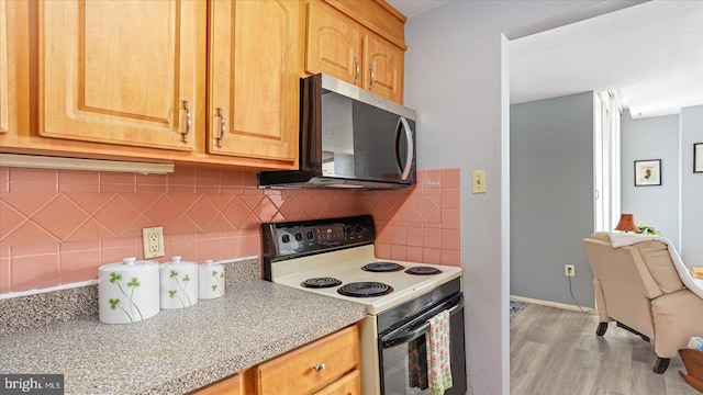 28 Allegheny Ave Unit 2505, Baltimore, MD 21204 - kitchen with electric stove, light countertops, light wood-type flooring, tasteful backsplash, and baseboards