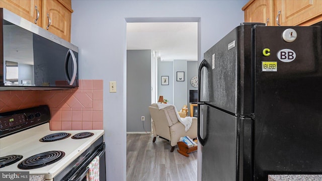 28 Allegheny Ave Unit 2505, Baltimore, MD 21204 - kitchen featuring freestanding refrigerator, range with electric stovetop, stainless steel microwave, light wood-style flooring, and backsplash