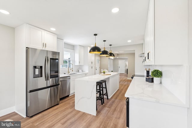 977 W Parkins Mill Rd, Winchester, VA 22602 - kitchen featuring stainless steel appliances, a center island, light wood-style flooring, a breakfast bar area, and white cabinets
