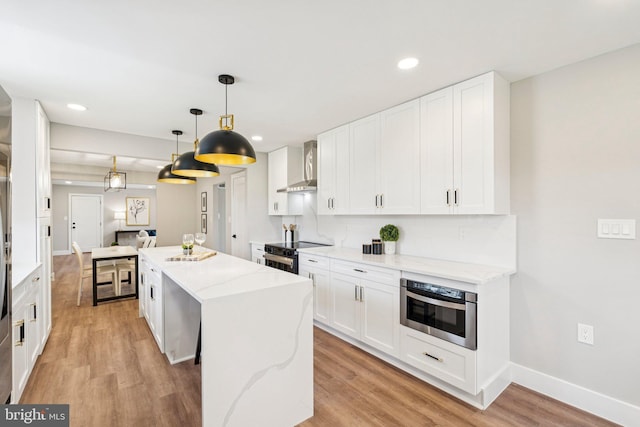 977 W Parkins Mill Rd, Winchester, VA 22602 - kitchen with wall chimney exhaust hood, a kitchen island, light wood-type flooring, white cabinets, and electric range