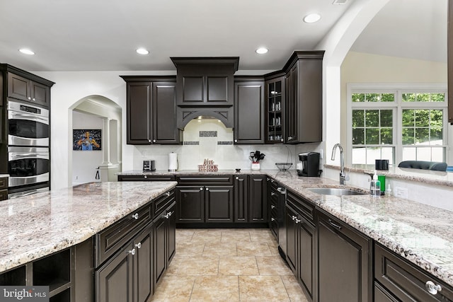99 Kresson Gibbsboro Rd, Voorhees, NJ 08043 - kitchen with arched walkways, a sink, glass insert cabinets, light stone counters, and decorative backsplash