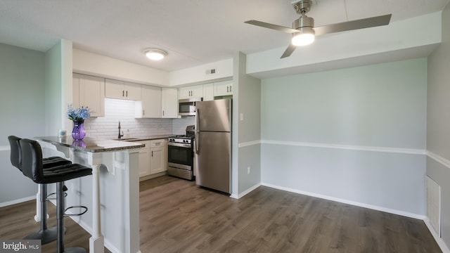 7205 Hilltop Dr Unit 95, Brookhaven, PA 19015 - kitchen with stainless steel appliances, a sink, dark wood-type flooring, a peninsula, and white cabinets