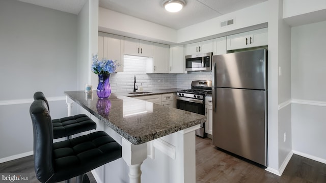 7205 Hilltop Dr Unit 95, Brookhaven, PA 19015 - kitchen featuring appliances with stainless steel finishes, a sink, a peninsula, white cabinetry, and backsplash