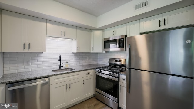 7205 Hilltop Dr Unit 95, Brookhaven, PA 19015 - kitchen featuring appliances with stainless steel finishes, a sink, stone countertops, and decorative backsplash
