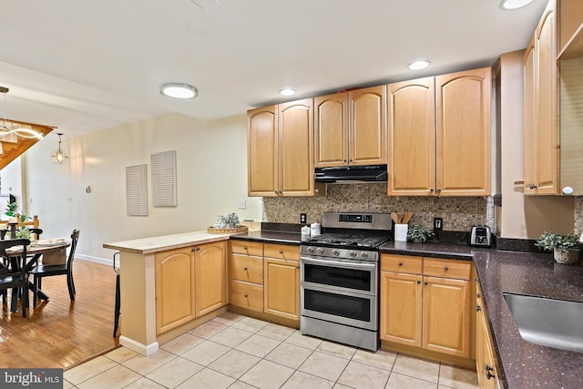 1708 Webster St, Baltimore, MD 21230 - kitchen with double oven range, under cabinet range hood, a peninsula, light tile patterned floors, and decorative backsplash