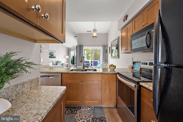 39770 E Sun Dr Unit 125, Fenwick Island, DE 19944 - kitchen with black appliances, brown cabinets, a peninsula, light stone countertops, and light wood finished floors