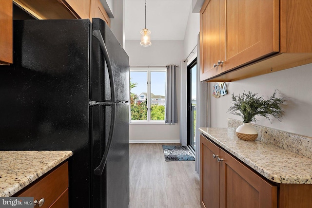 39770 E Sun Dr Unit 125, Fenwick Island, DE 19944 - kitchen with freestanding refrigerator, light wood finished floors, and brown cabinetry