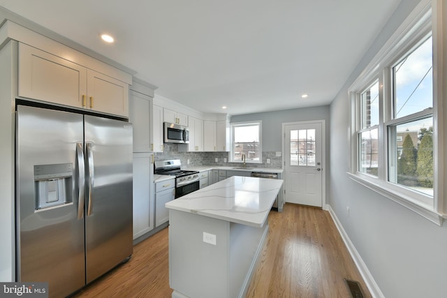 12008 Elmore Rd, Philadelphia, PA 19154 - kitchen with stainless steel appliances, a sink, decorative backsplash, light wood-style flooring, and recessed lighting