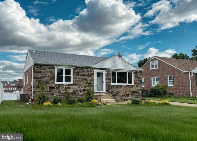 12008 Elmore Rd, Philadelphia, PA 19154 - view of front of property with stone siding, central air condition unit, a front yard, and a chimney