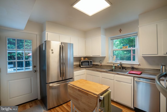 5021 23rd Rd N, Arlington, VA 22207 - kitchen featuring stainless steel appliances, a sink, healthy amount of natural light, and white cabinets