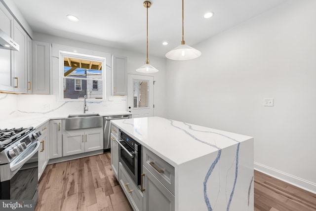 267 S Ellwood Ave, Baltimore, MD 21224 - kitchen with stainless steel appliances, light wood-type flooring, a kitchen island, a sink, and recessed lighting