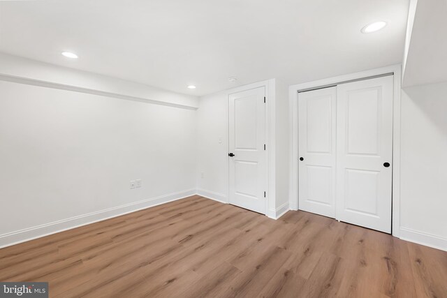 267 S Ellwood Ave, Baltimore, MD 21224 - unfurnished bedroom with light wood-style flooring, a closet, baseboards, and recessed lighting