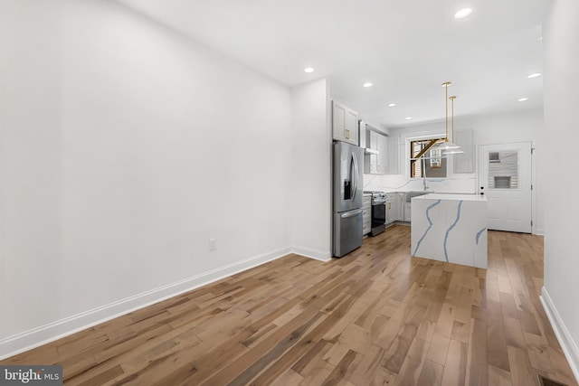 267 S Ellwood Ave, Baltimore, MD 21224 - kitchen featuring appliances with stainless steel finishes, light wood-style floors, recessed lighting, hanging light fixtures, and white cabinetry