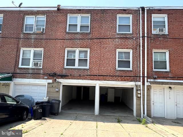 7113 Castor Ave, Philadelphia, PA 19149 - back of house featuring an attached garage, driveway, and brick siding