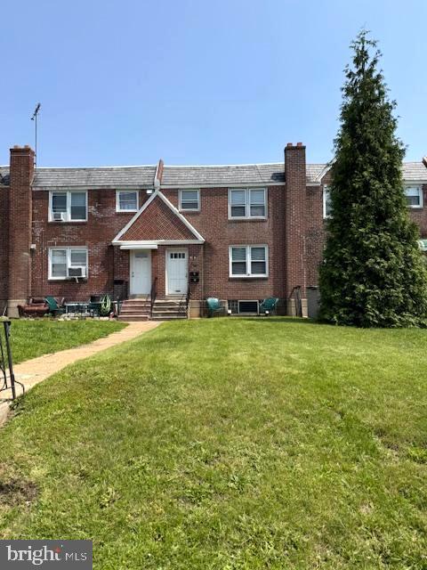 7113 Castor Ave, Philadelphia, PA 19149 - view of front of home with a front yard, brick siding, and a chimney