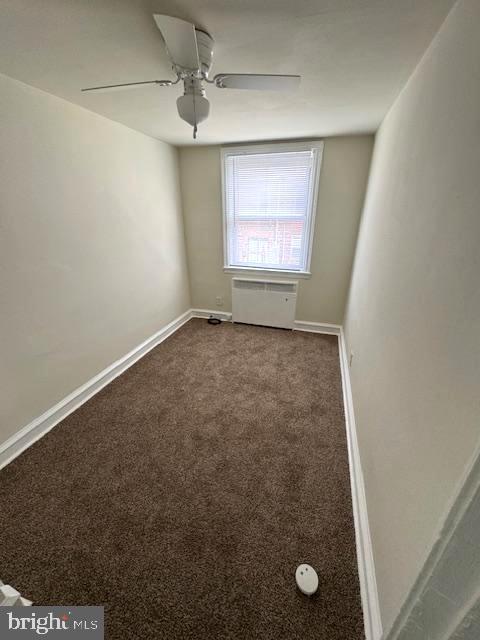 7113 Castor Ave, Philadelphia, PA 19149 - empty room with dark carpet, radiator, ceiling fan, and baseboards