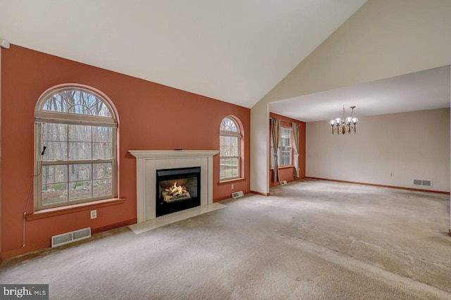 3115 Sparrow Ct, East Stroudsburg, PA 18302 - unfurnished living room featuring a chandelier, a fireplace with flush hearth, carpet floors, plenty of natural light, and high vaulted ceiling