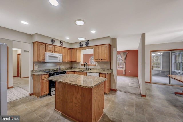 3115 Sparrow Ct, East Stroudsburg, PA 18302 - kitchen with white appliances, a sink, a center island, baseboards, and light stone counters
