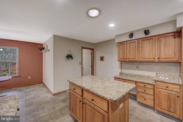 3115 Sparrow Ct, East Stroudsburg, PA 18302 - kitchen with a kitchen island, light stone counters, baseboards, brown cabinets, and recessed lighting