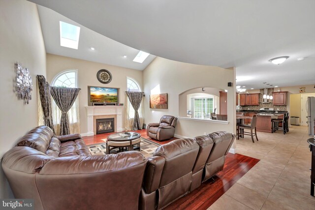 118 Connecticut Ave, Sinking Spring, PA 19608 - living area with a skylight, healthy amount of natural light, a glass covered fireplace, lofted ceiling, and light tile patterned flooring