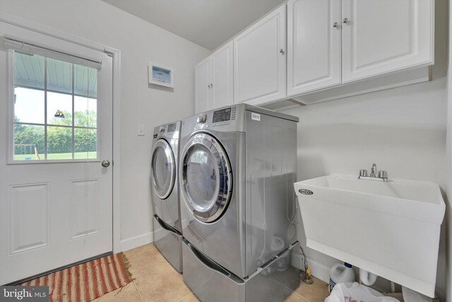 118 Connecticut Ave, Sinking Spring, PA 19608 - laundry area featuring washer and dryer, cabinet space, light tile patterned floors, and baseboards