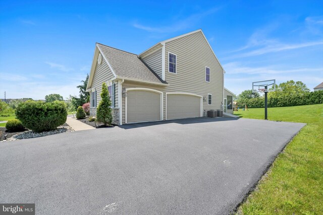 118 Connecticut Ave, Sinking Spring, PA 19608 - view of side of property with an attached garage, a yard, cooling unit, asphalt driveway, and a shingled roof