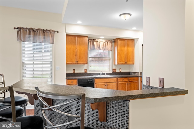5529 Briar Ln, Whitehall, PA 18052 - kitchen featuring dishwasher, a sink, a breakfast bar, dark countertops, and a peninsula