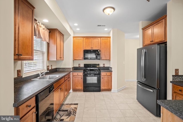 5529 Briar Ln, Whitehall, PA 18052 - kitchen with black appliances, a sink, dark countertops, light tile patterned floors, and brown cabinetry