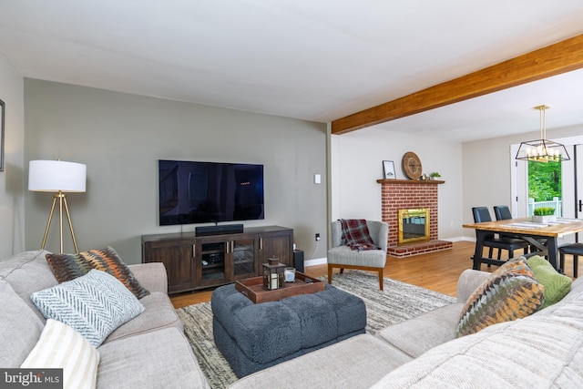 40 Grays Ln, Elverson, PA 19520 - living room featuring a brick fireplace, wood finished floors, a chandelier, beamed ceiling, and baseboards