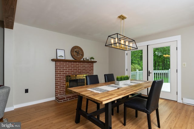 40 Grays Ln, Elverson, PA 19520 - dining area featuring light wood finished floors, a brick fireplace, baseboards, and a chandelier