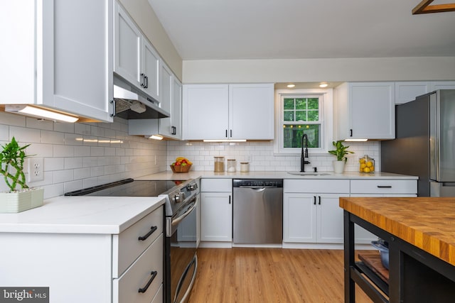 40 Grays Ln, Elverson, PA 19520 - kitchen with appliances with stainless steel finishes, a sink, under cabinet range hood, white cabinetry, and backsplash