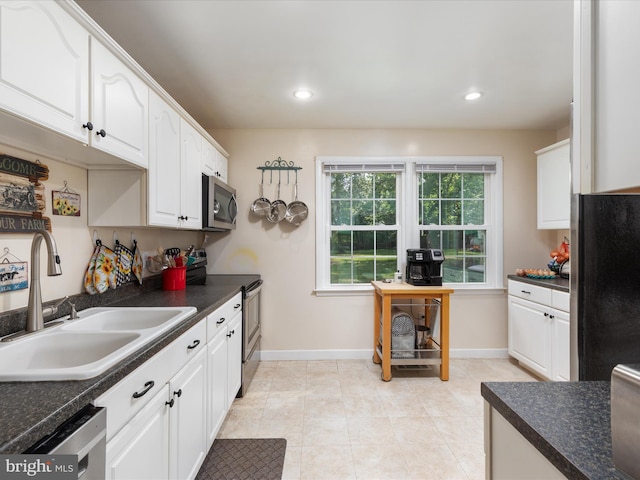 13610 Aden Rd, Nokesville, VA 20181 - kitchen featuring appliances with stainless steel finishes, a sink, dark countertops, white cabinets, and recessed lighting