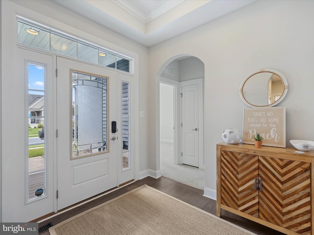 33512 Auburn Dr, Rehoboth Beach, DE 19971 - foyer featuring dark wood finished floors, crown molding, arched walkways, plenty of natural light, and baseboards