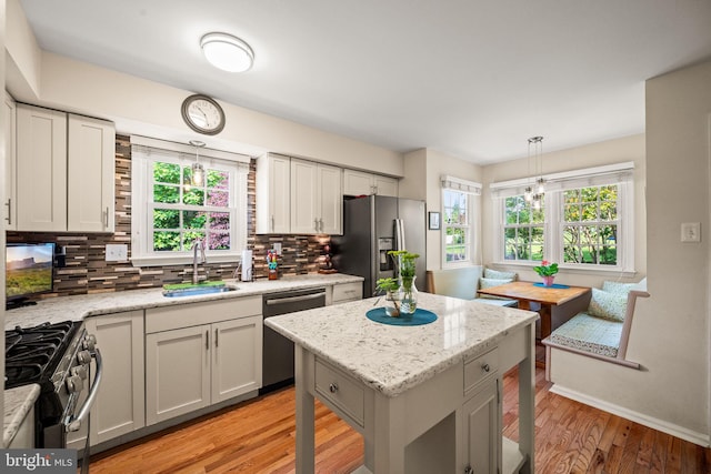 503 Emily Cir, West Chester, PA 19382 - kitchen with stainless steel appliances, a sink, tasteful backsplash, light wood-style floors, and decorative light fixtures