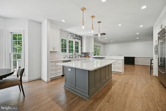 4788 Charter Ct, Woodbridge, VA 22192 - kitchen featuring light countertops, white cabinets, a kitchen island, a peninsula, and tasteful backsplash
