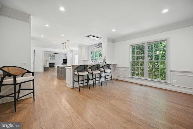 4788 Charter Ct, Woodbridge, VA 22192 - kitchen featuring crown molding, a kitchen bar, recessed lighting, a fireplace, and light wood finished floors