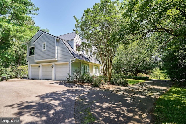 37193 Adams Green Ln, Middleburg, VA 20117 - view of home's exterior featuring asphalt driveway, a metal roof, an attached garage, and a gambrel roof