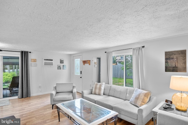 109 Knob Ct, Albrightsville, PA 18210 - living room with a textured ceiling, healthy amount of natural light, light wood-style floors, and a wall unit AC