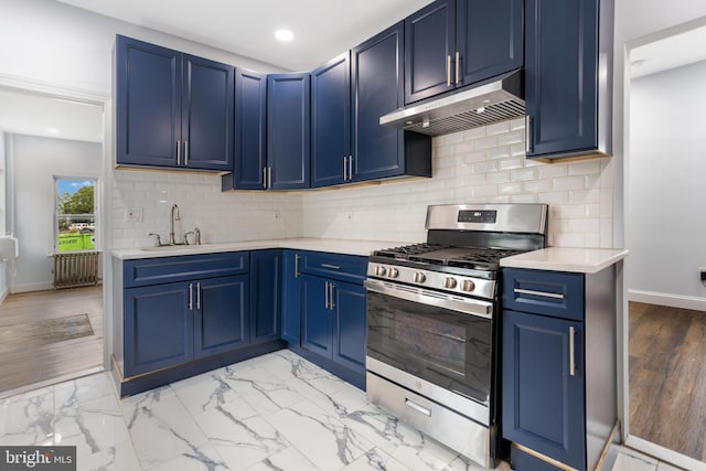 213 Franklin St, Hightstown, NJ 08520 - kitchen with stainless steel gas stove, under cabinet range hood, blue cabinets, a sink, and light countertops
