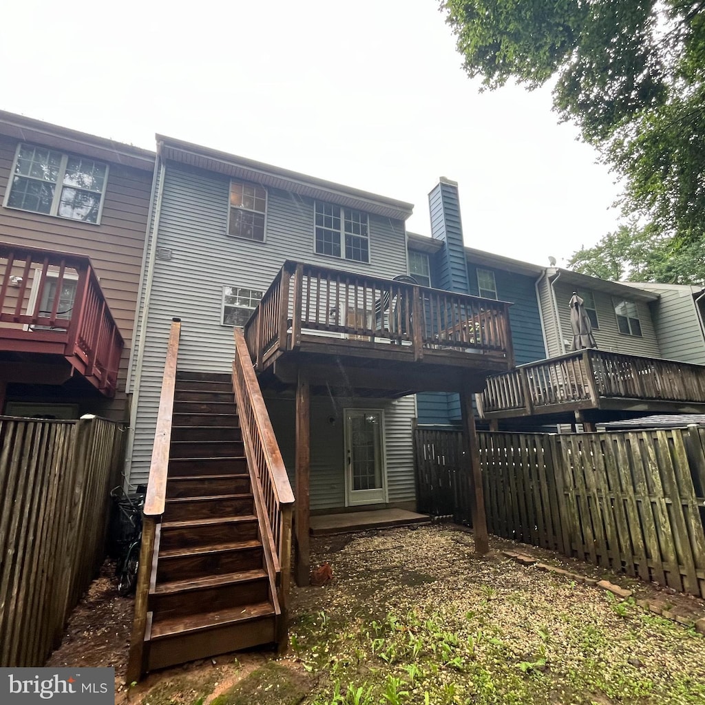 15232 Streamside Ct, Dumfries, VA 22025 - rear view of property featuring a fenced backyard, a deck, a chimney, and stairs